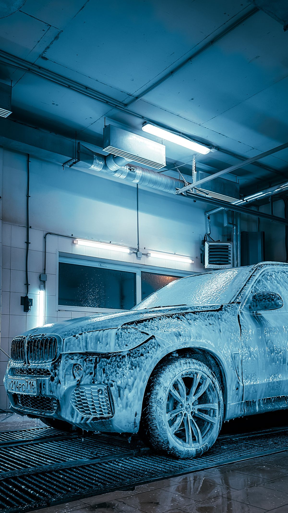 Luxus-SUV in moderner Autowaschanlage mit Schaum