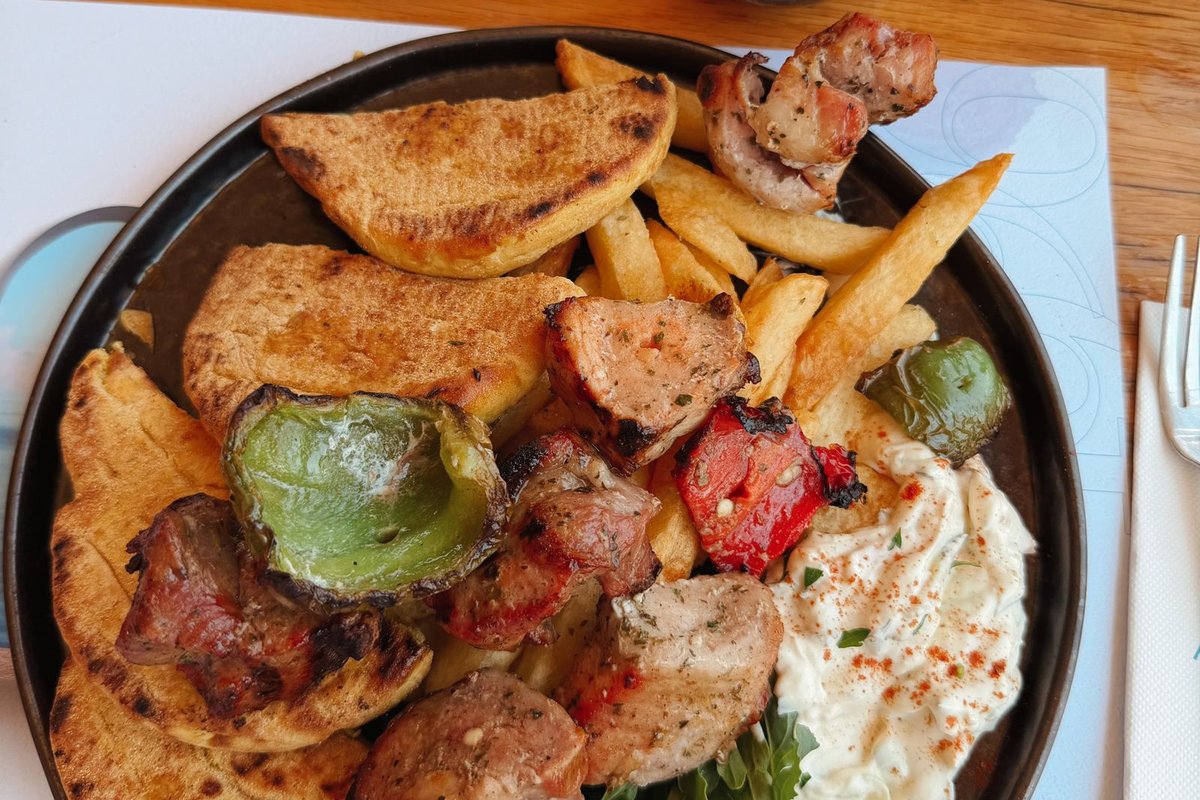 Griechischer Grillteller mit Souvlaki, Pita, Pommes und Tzatziki