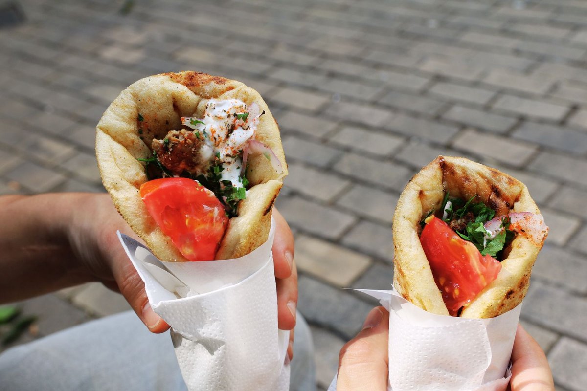Zwei Pita Gyros mit Tomaten in Papier zum Mitnehmen
